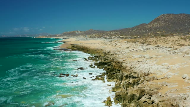 LA LAGUNA BEACH LOS CABOS MEXICO-2021: Waves Crashing on Rocky Coastline with Sandy Beach