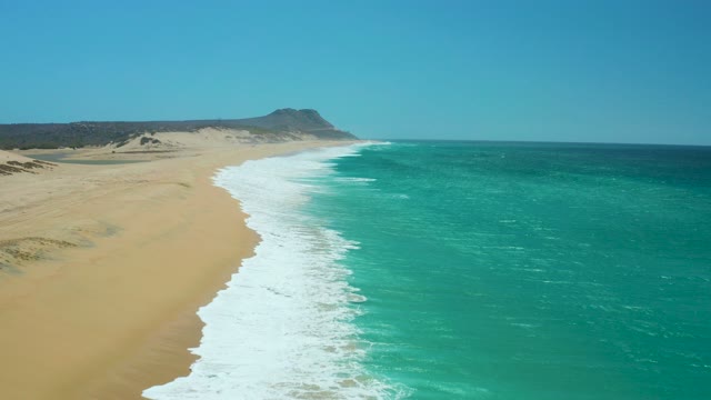 LA LAGUNA BEACH LOS CABOS MEXICO-2021: Waves Rolling Onto Golden Sandy Shore