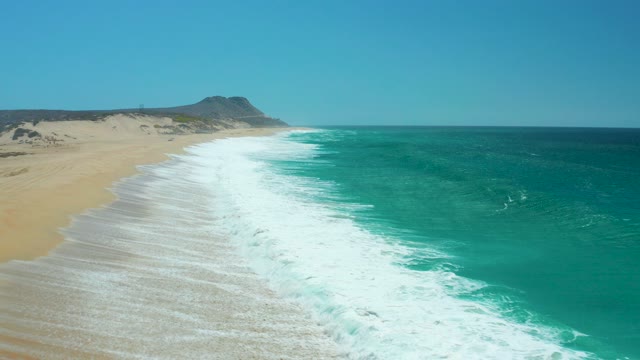LA LAGUNA BEACH LOS CABOS MEXICO-2021: Ocean Waves Rolling Onto Sandy Beach