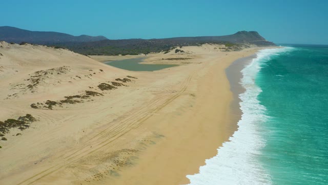 LA LAGUNA BEACH LOS CABOS MEXICO-2021: Waves Crashing on Sandy Beach with Dunes