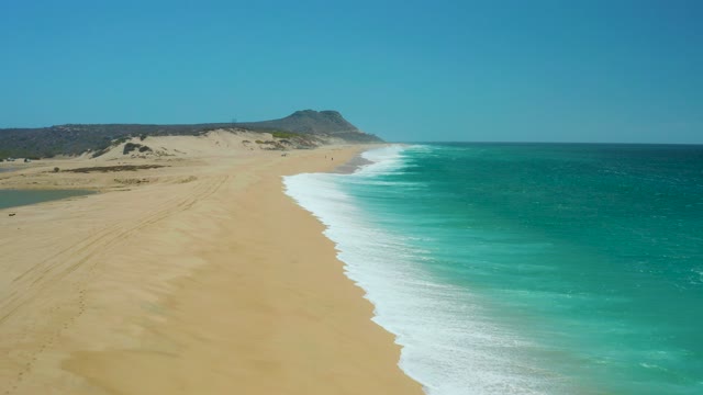 LA LAGUNA BEACH LOS CABOS MEXICO-2021: Gentle Ocean Waves Rolling Onto Sandy Shore
