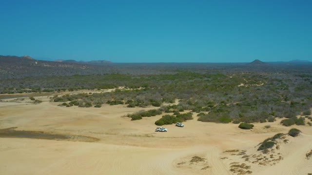 LA LAGUNA BEACH LOS CABOS MEXICO-2021: Two SUVs Driving Across Sandy Dunes