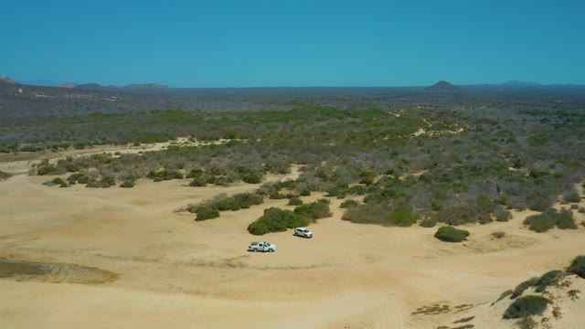 LA LAGUNA BEACH LOS CABOS MEXICO-2021: Two SUVs Driving Through Arid Desert Terrain