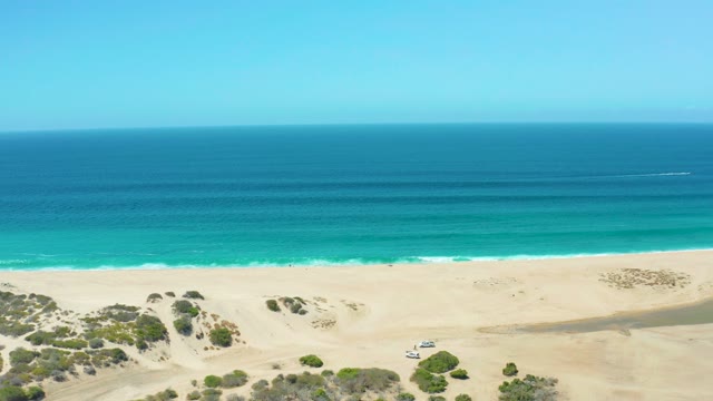 LA LAGUNA BEACH LOS CABOS MEXICO-2021: Car Moving on Sandy Beach by Turquoise Ocean