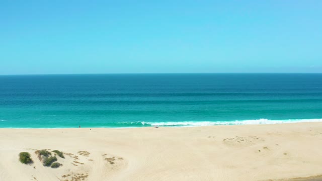 LA LAGUNA BEACH LOS CABOS MEXICO-2021: Waves Crashing on Sandy Shore From Elevated View
