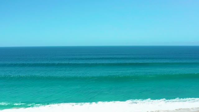 LA LAGUNA BEACH LOS CABOS MEXICO-2021: Gentle Ocean Wave Approaching Sandy Shoreline