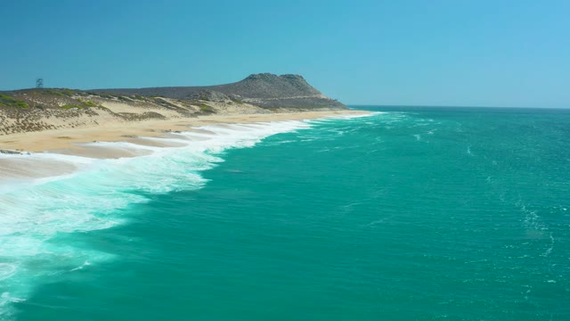 LA LAGUNA BEACH LOS CABOS MEXICO-2021: Waves Rolling Onto Sandy Beach with Turquoise Water