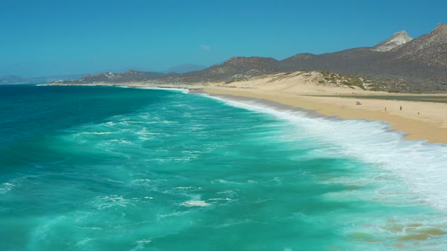 LA LAGUNA BEACH LOS CABOS MEXICO-2021: Ocean Waves Rolling Onto Sandy Beach