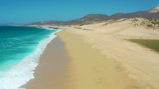 LA LAGUNA BEACH LOS CABOS MEXICO-2021: Ocean Waves Rolling Onto Sandy Beach From Aerial View