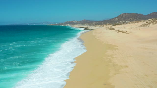 LA LAGUNA BEACH LOS CABOS MEXICO-2021: Gentle Ocean Waves Rolling Onto Sandy Beach