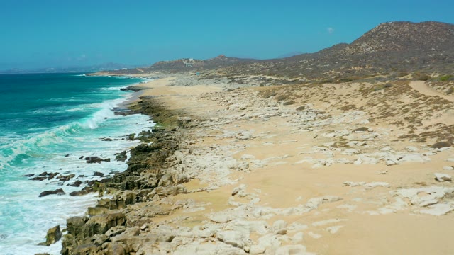 LA LAGUNA BEACH LOS CABOS MEXICO-2021: Coastal Beach with Turquoise Waves and Rocky Shoreline