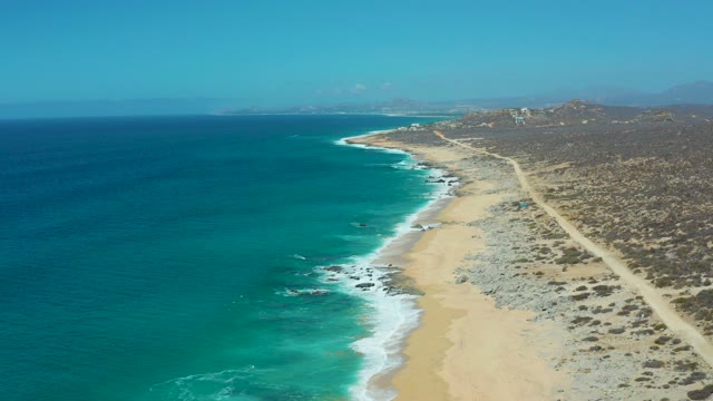 LA LAGUNA BEACH LOS CABOS MEXICO-2021: Coastal Shoreline with Moving Boat and Dirt Road