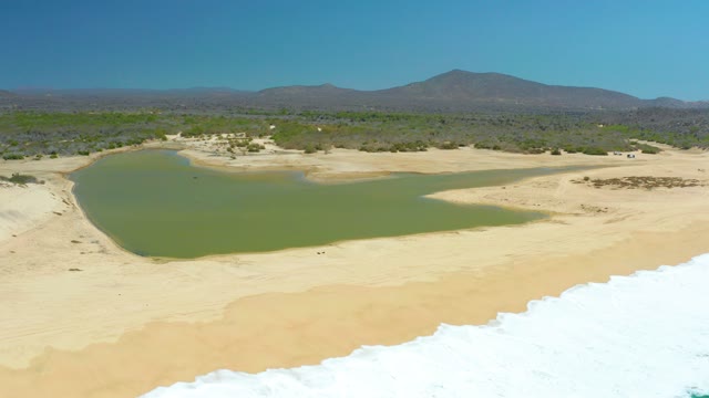 LA LAGUNA BEACH LOS CABOS MEXICO-2021: Lagoon and Sandy Shore with Receding Ocean Waves