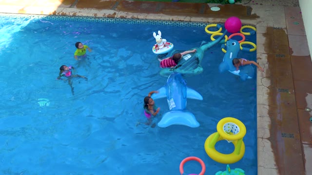 SAN JOSE DEL CABO BCS MEXICO-2020: Children Playing with Pool Toys in a Backyard Pool
