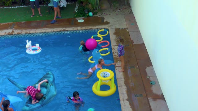 SAN JOSE DEL CABO BCS MEXICO-2020: Children Playing in Backyard Pool with Inflatable Toys