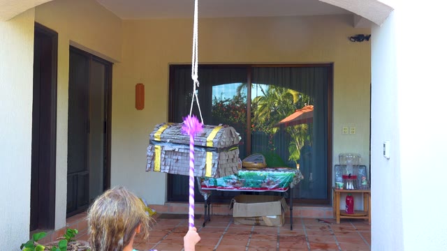 SAN JOSE DEL CABO BCS MEXICO-2020: Child Hitting a Hanging Piñata on a Patio