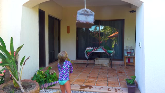 SAN JOSE DEL CABO BCS MEXICO-2020: Child Swinging a Piñata on a Patio