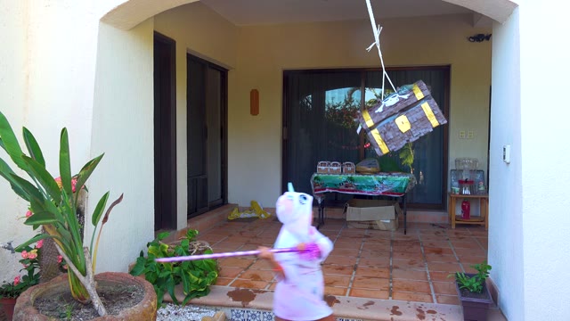 SAN JOSE DEL CABO BCS MEXICO-2020: Child in White Onesie Hitting a Hanging Piñata