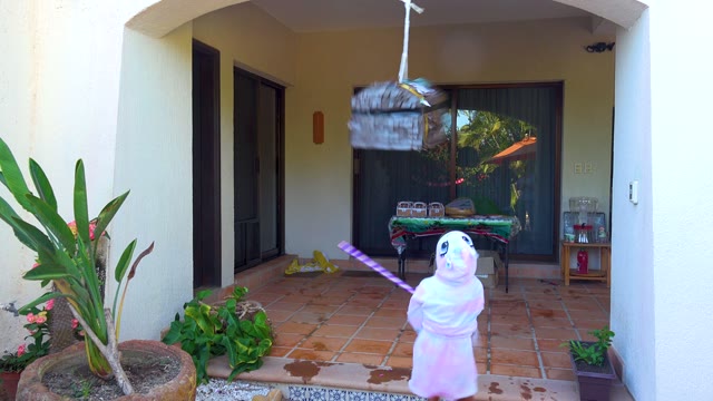 SAN JOSE DEL CABO BCS MEXICO-2020: Child Hitting Piñata on Outdoor Patio