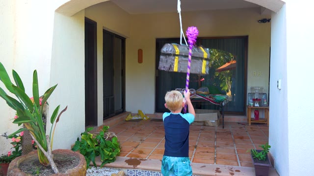 SAN JOSE DEL CABO BCS MEXICO-2020: Child Hitting a Piñata in a Courtyard