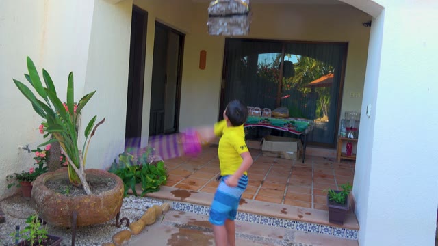 SAN JOSE DEL CABO BCS MEXICO-2020: Child Hitting a Piñata on a Patio