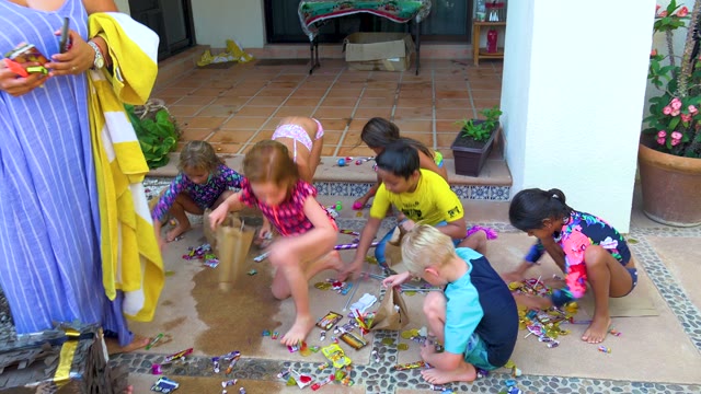 SAN JOSE DEL CABO BCS MEXICO-2020: Kids Gathering Candy on Tiled Patio