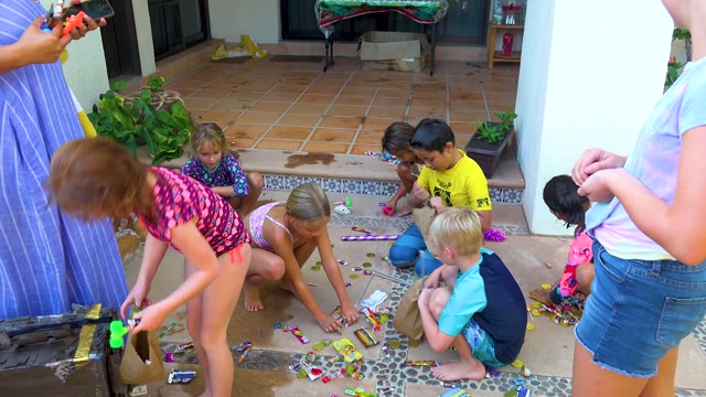 SAN JOSE DEL CABO BCS MEXICO-2020: Children Picking Up Candies on a Patio Floor