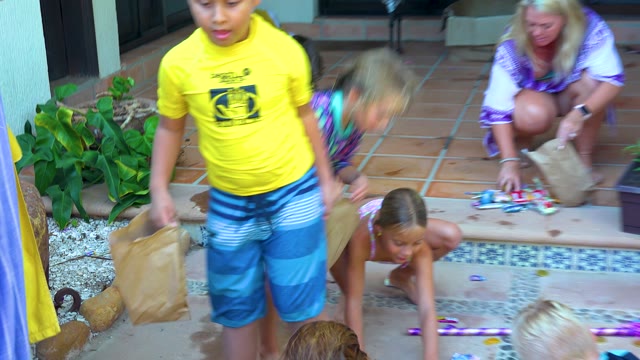 SAN JOSE DEL CABO BCS MEXICO-2020: Children Collecting Items in Paper Bags on a Patio