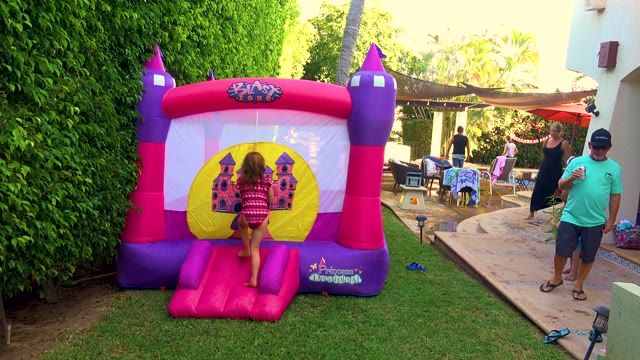 SAN JOSE DEL CABO BCS MEXICO-2020: Children Playing on Inflatable Bounce House in Backyard