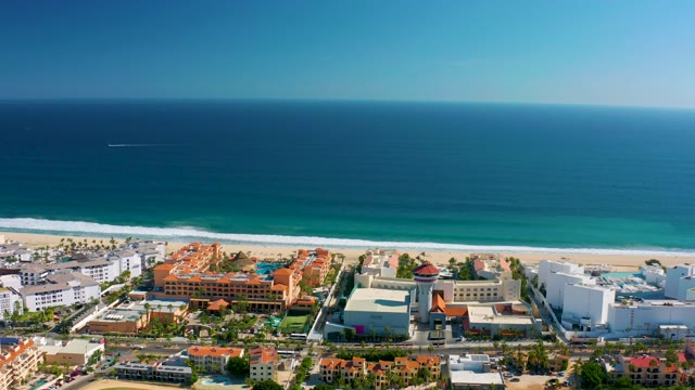 SAN JOSE DEL CABO MEXICO-2020: Waves Breaking on Sandy Beach Near Coastal Buildings
