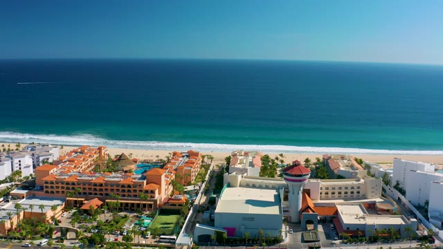 SAN JOSE DEL CABO MEXICO-2020: Ocean Waves Approaching Sandy Beach with Coastal Buildings