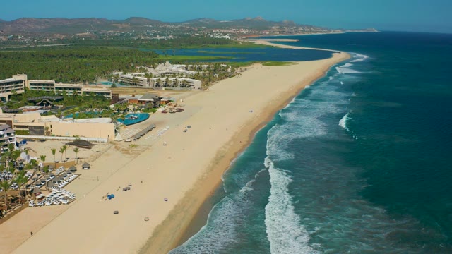 SAN JOSE DEL CABO MEXICO-2020: Sandy Beach with Resort Buildings and Ocean Waves