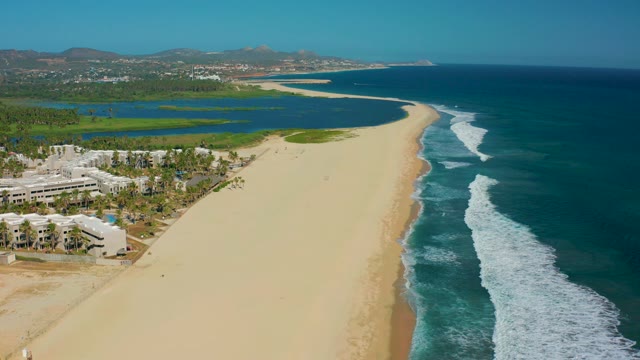 SAN JOSE DEL CABO MEXICO-2020: Sandy Beach with Ocean Waves and Resort Buildings