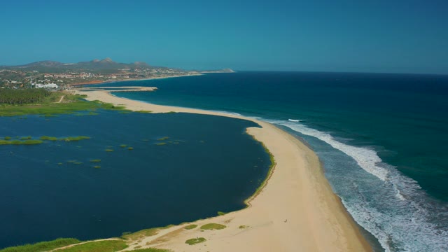 SAN JOSE DEL CABO MEXICO-2020: People Walking on Sandy Spit Between Lagoon and Ocean