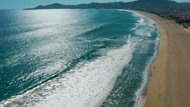 SAN JOSE DEL CABO MEXICO-2020: Waves Rolling Onto Sandy Beach with People Walking