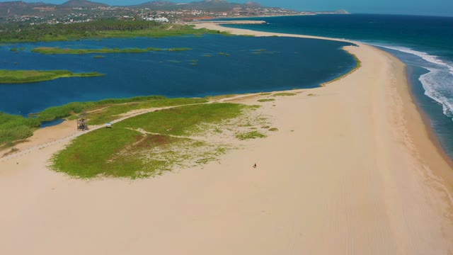 SAN JOSE DEL CABO MEXICO-2020: Sandy Beach, Lagoon, and People Moving Along Shore