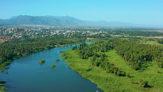 SAN JOSE DEL CABO MEXICO-2020: Winding River with Lush Banks and Distant Cityscape