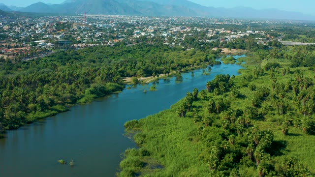 SAN JOSE DEL CABO MEXICO-2020: River Flowing Through Green Landscape with Town in Background
