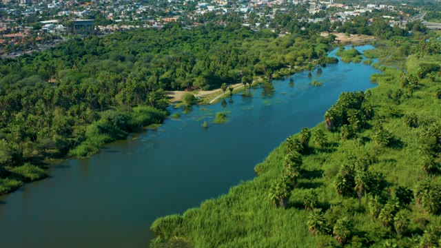 SAN JOSE DEL CABO MEXICO-2020: River Winding Through Lush Greenery and Urban Area