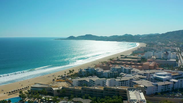 SAN JOSE DEL CABO MEXICO-2020: Sandy Beach and Ocean Waves with Coastal Resort Buildings