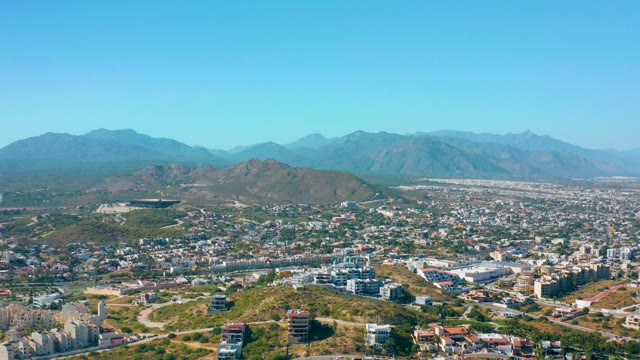 SAN JOSE DEL CABO MEXICO-2020: Cityscape with Moving Vehicle and Mountain Backdrop