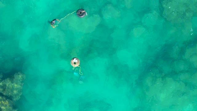 SAN JOSE DEL CABO BCS MEXICO-2020: Two People on Inflatable Floats in Shallow Turquoise Water