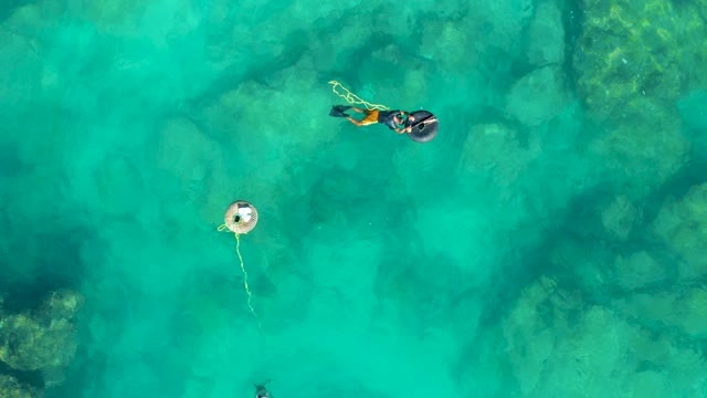 SAN JOSE DEL CABO BCS MEXICO-2020: Two Snorkelers and a Swimmer near a Buoy in Clear Turquoise Water