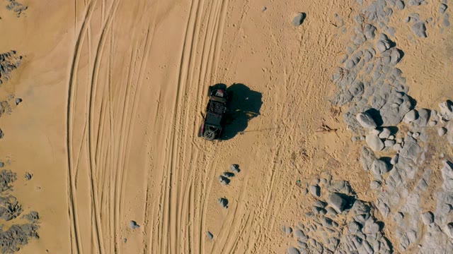 SAN JOSE DEL CABO BCS MEXICO-2020: SUV Driving Through Sandy Desert with Rock Formations