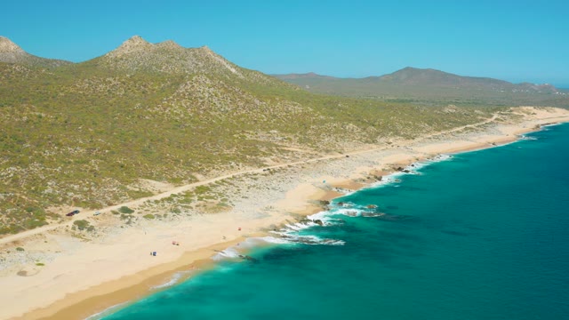 EAST CAPE BCS MEXICO-2020: Beachgoers Moving Along a Sandy Shore with Turquoise Ocean