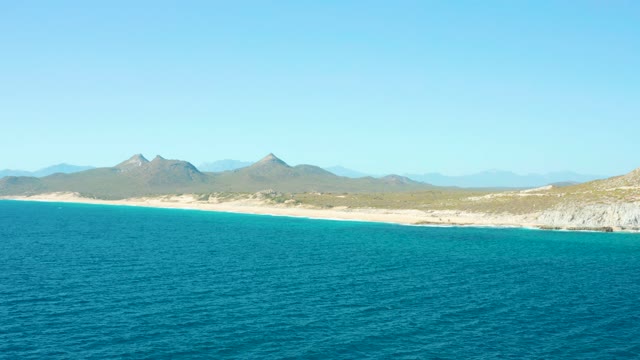 EAST CAPE BCS MEXICO-2020: Sandy Beach Bordered by Turquoise Ocean and Distant Mountains
