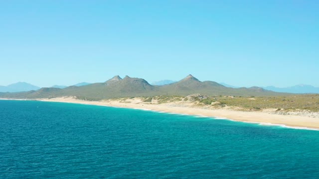 EAST CAPE BCS MEXICO-2020: Gentle Waves Rolling Onto Sandy Beach with Distant Mountains