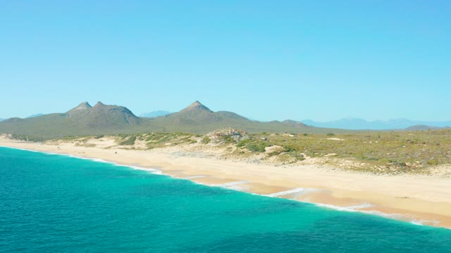 EAST CAPE BCS MEXICO-2020: Gentle Waves Rolling Onto a Sandy Beach with Mountain Backdrop