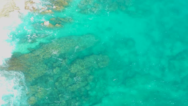 Shallow Turquoise Water Over Rocky Seabed by White Sand