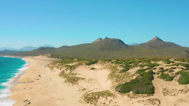 Coastal Dunes, Ocean Waves, and Mountain Backdrop